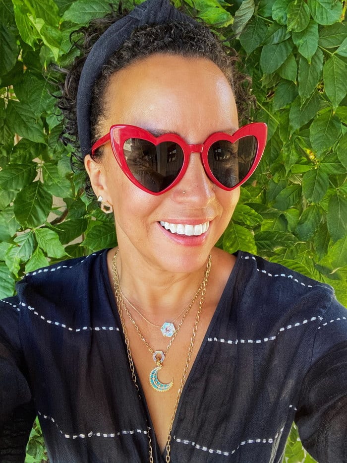 A woman wearing red heart shaped sunglasses.